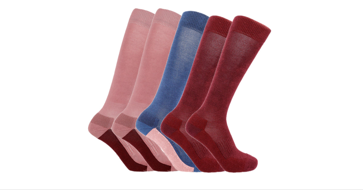 Five Soleberie Classic Long Socks  in pink, navy and burgundy, arranged in a fan shape against a plain white background.